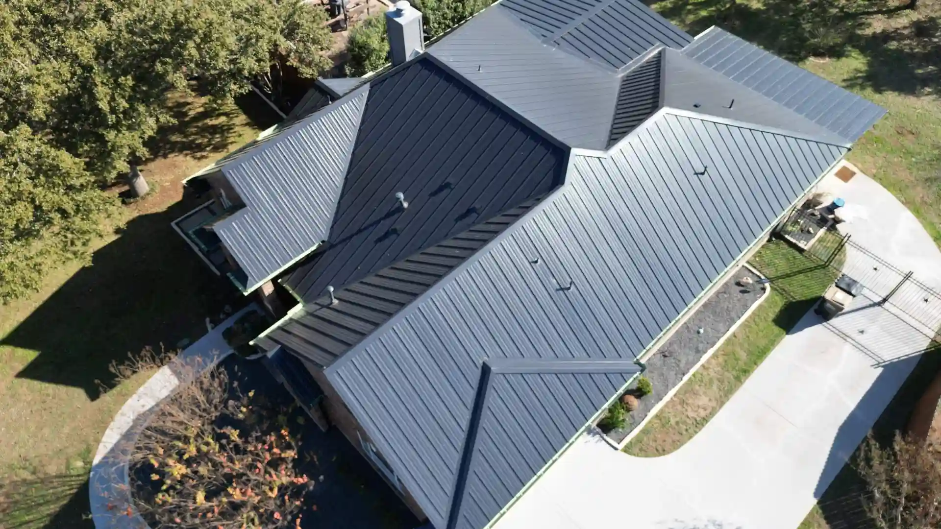 Aerial view of a modern home with a dark standing seam metal roof.